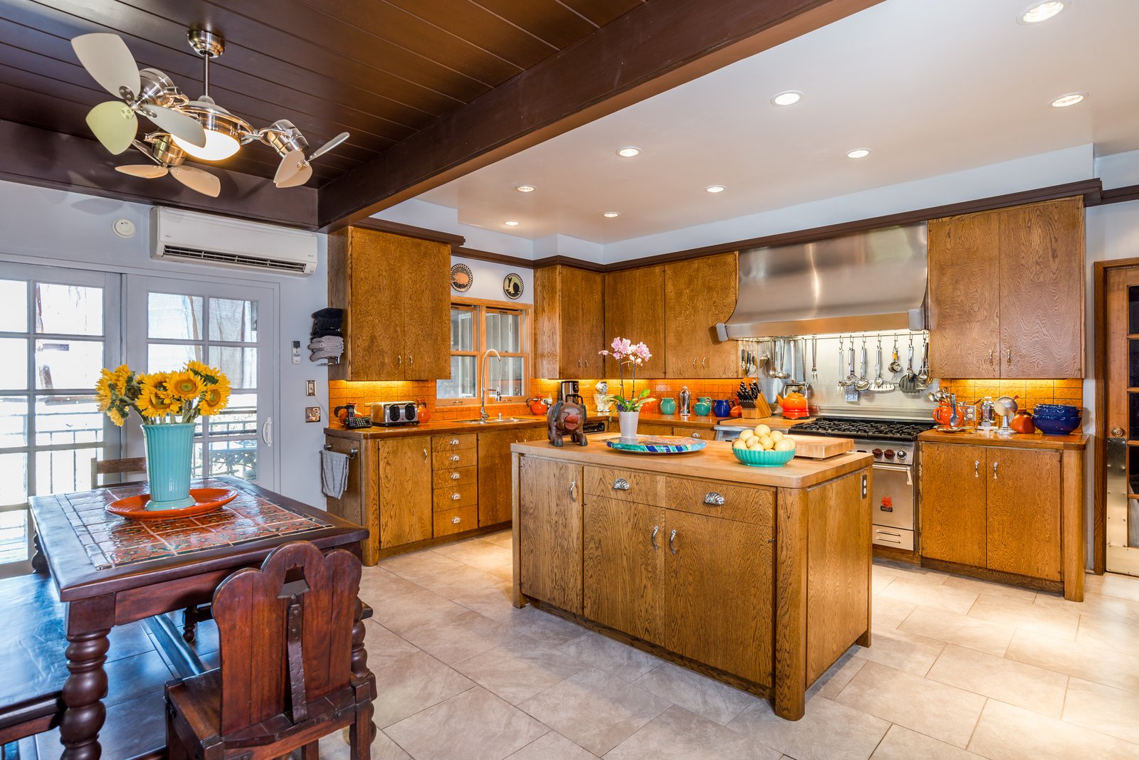 One of two full kitchens — Wolf range, butcher-block island, and a Spanish-tile breakfast table.