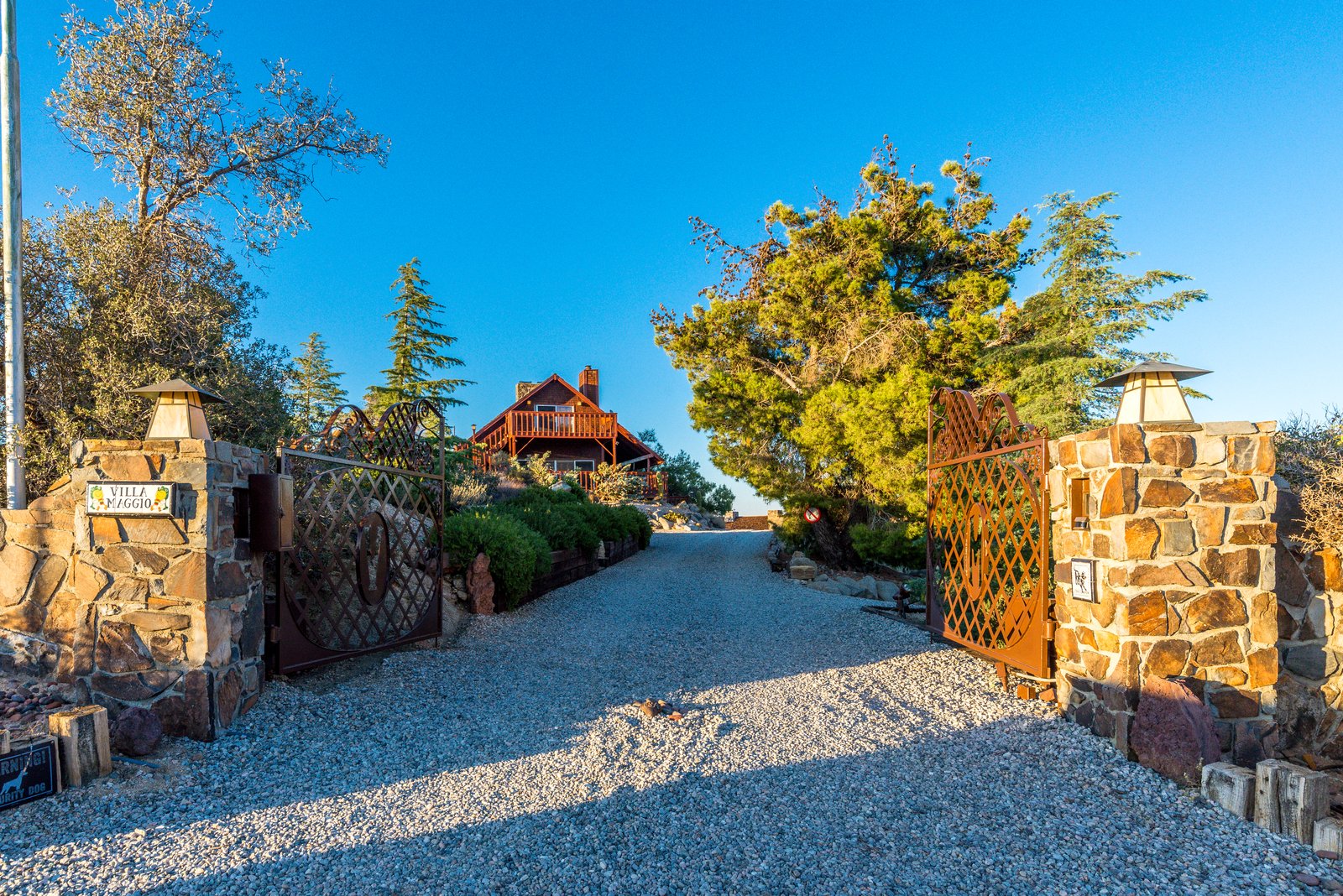 The Villa Maggio entrance gate — stone pillars and a wrought-iron name plaque.