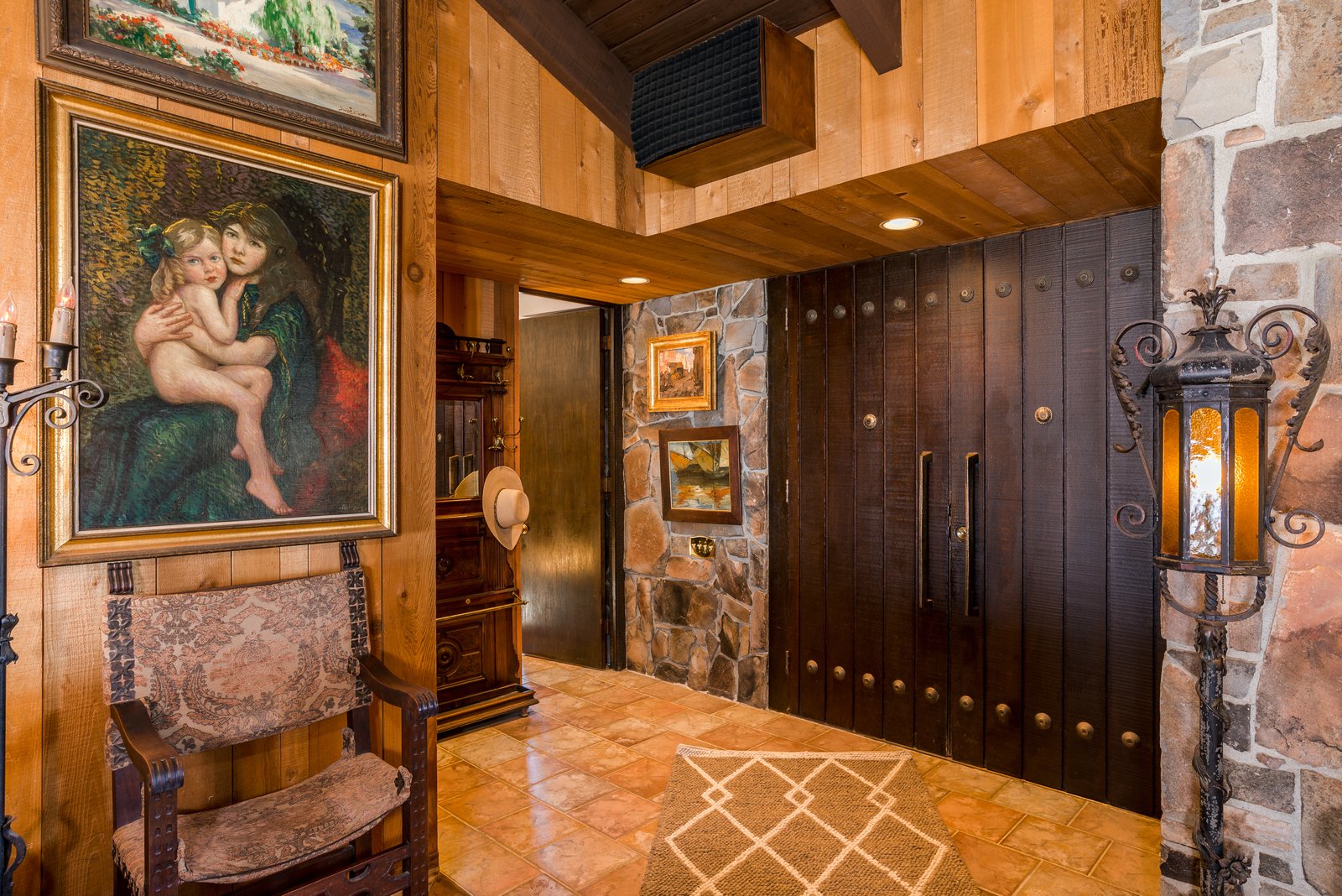 The entry foyer, with original stonework, paneled doors, and Sinatra-era artwork.