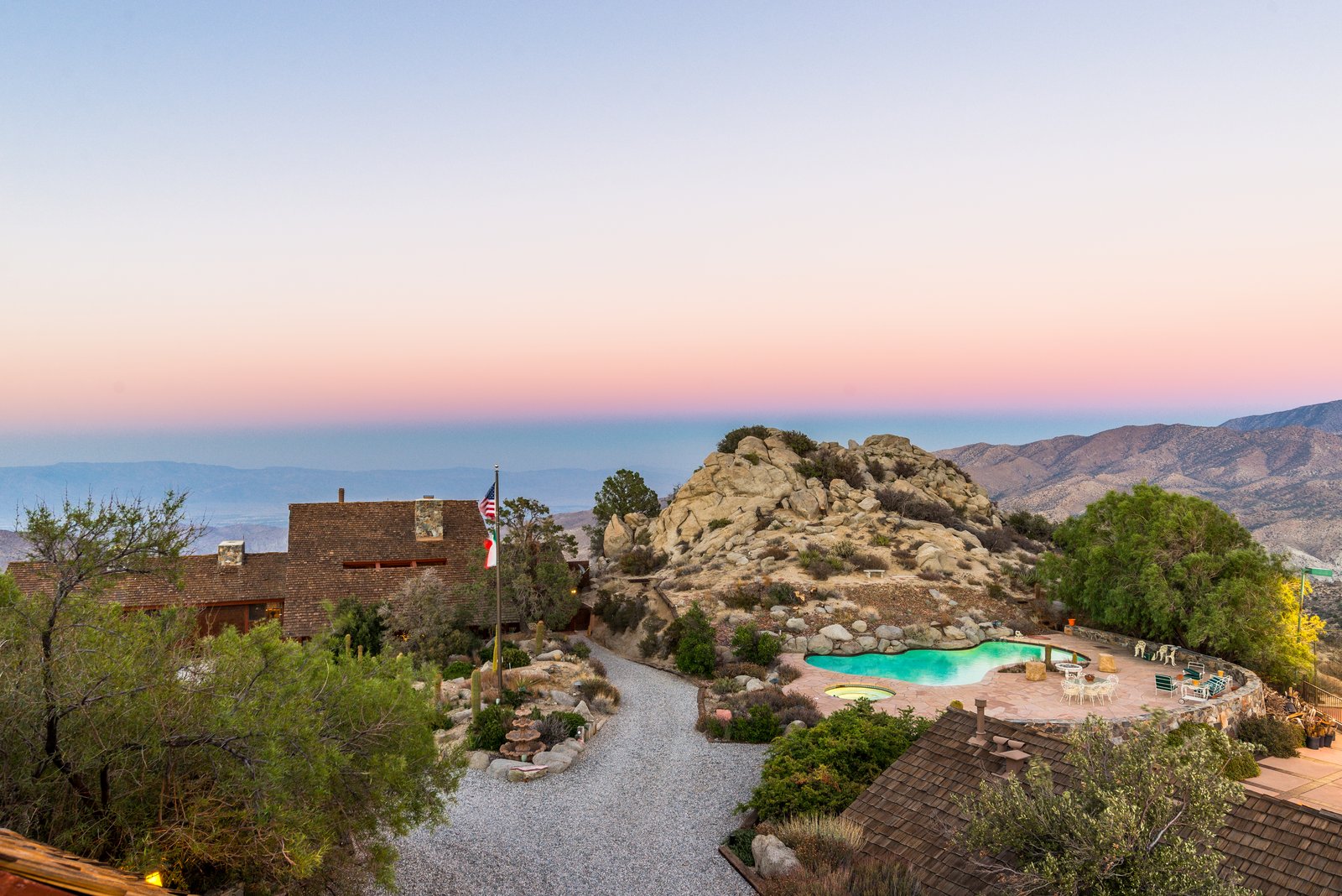 Pool and spa at dusk — set against the property's natural rock outcropping.